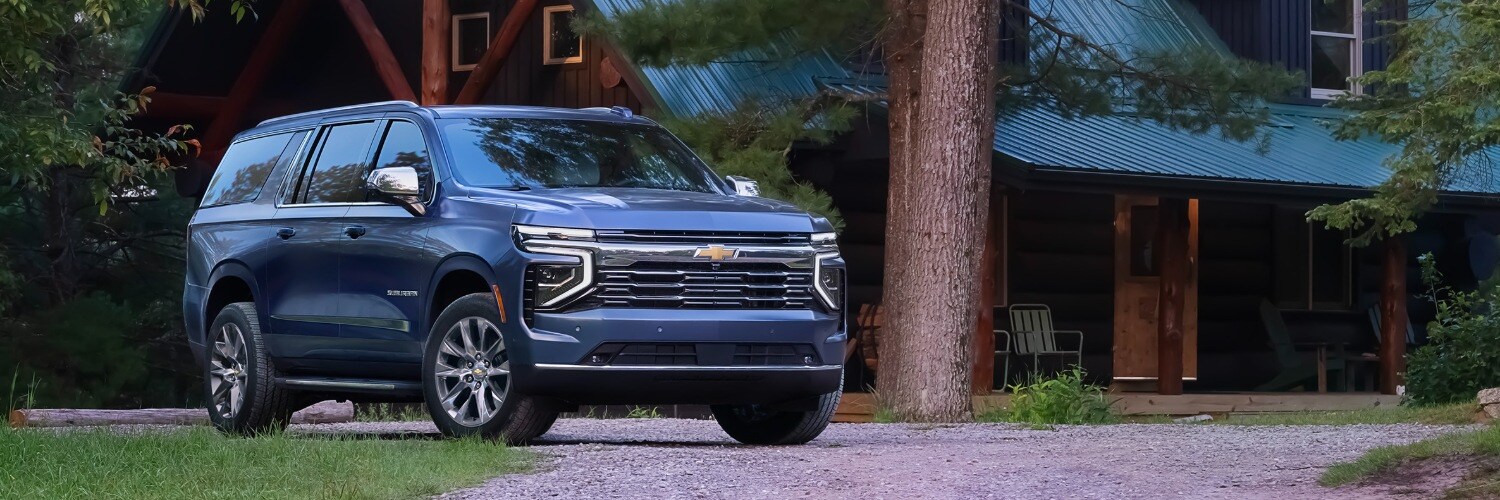 Dark Blue Chevy Suburban parked in front of an cabin