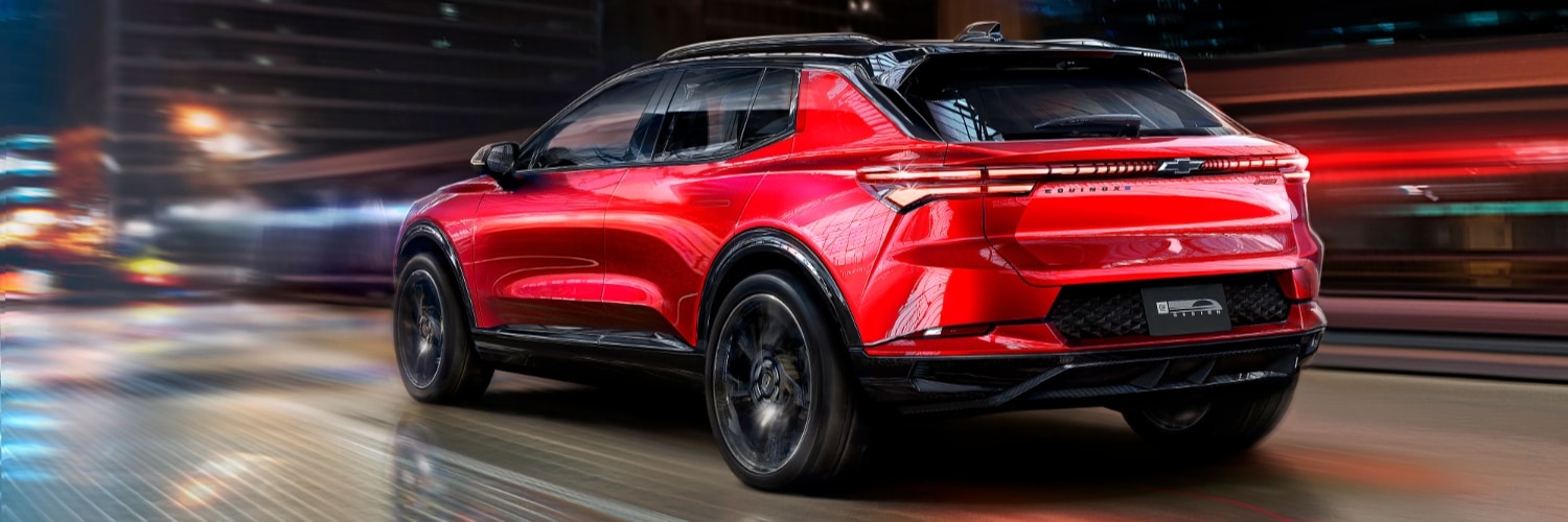 Red Chevy Equinox EV driving on a city road