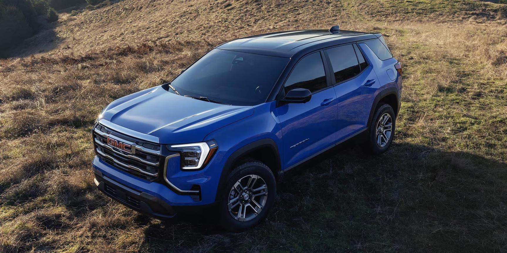 2026 GMC Terrain driving on a road with trees