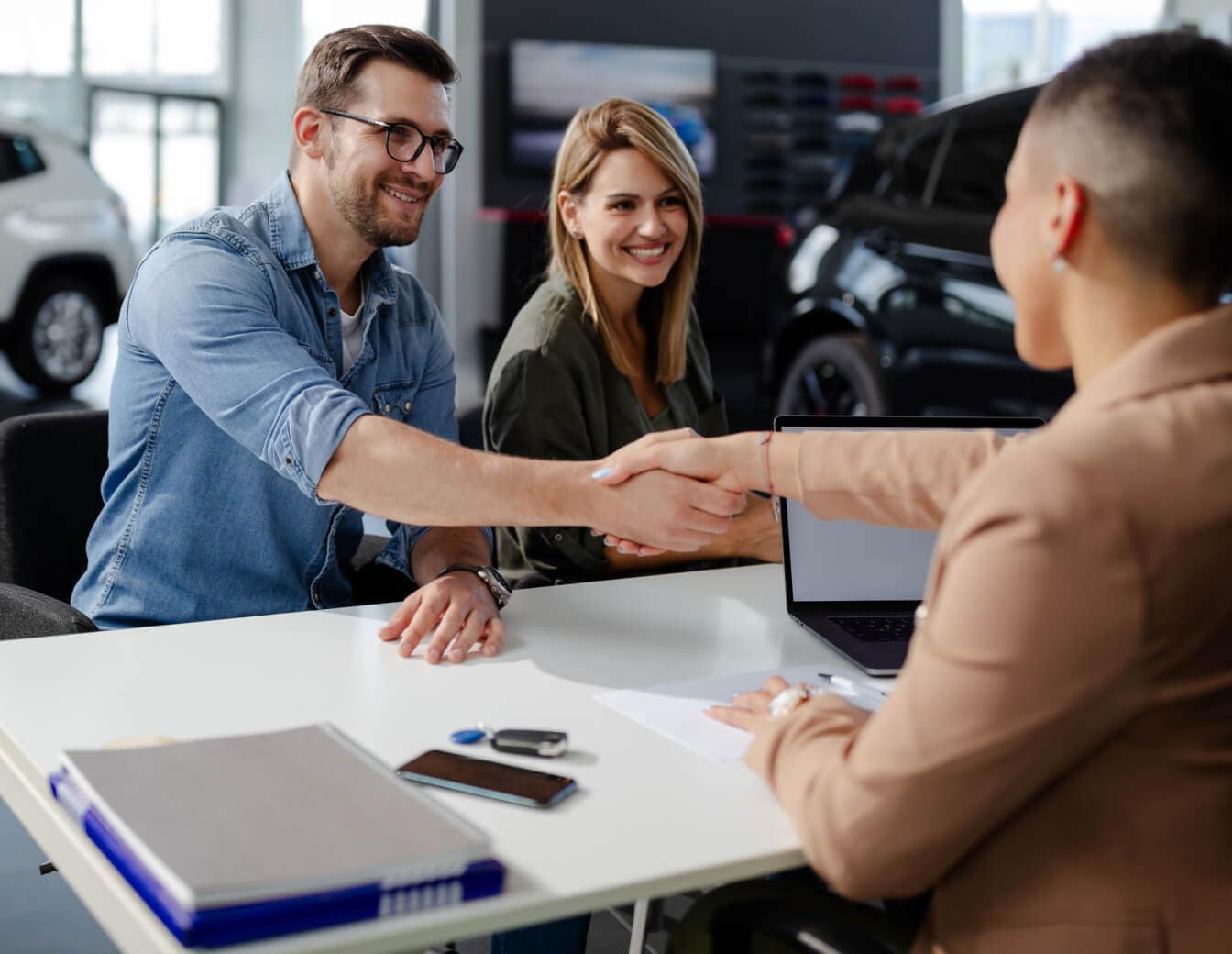 Happy couple finalizing deal on their dream Nissan vehicle.
