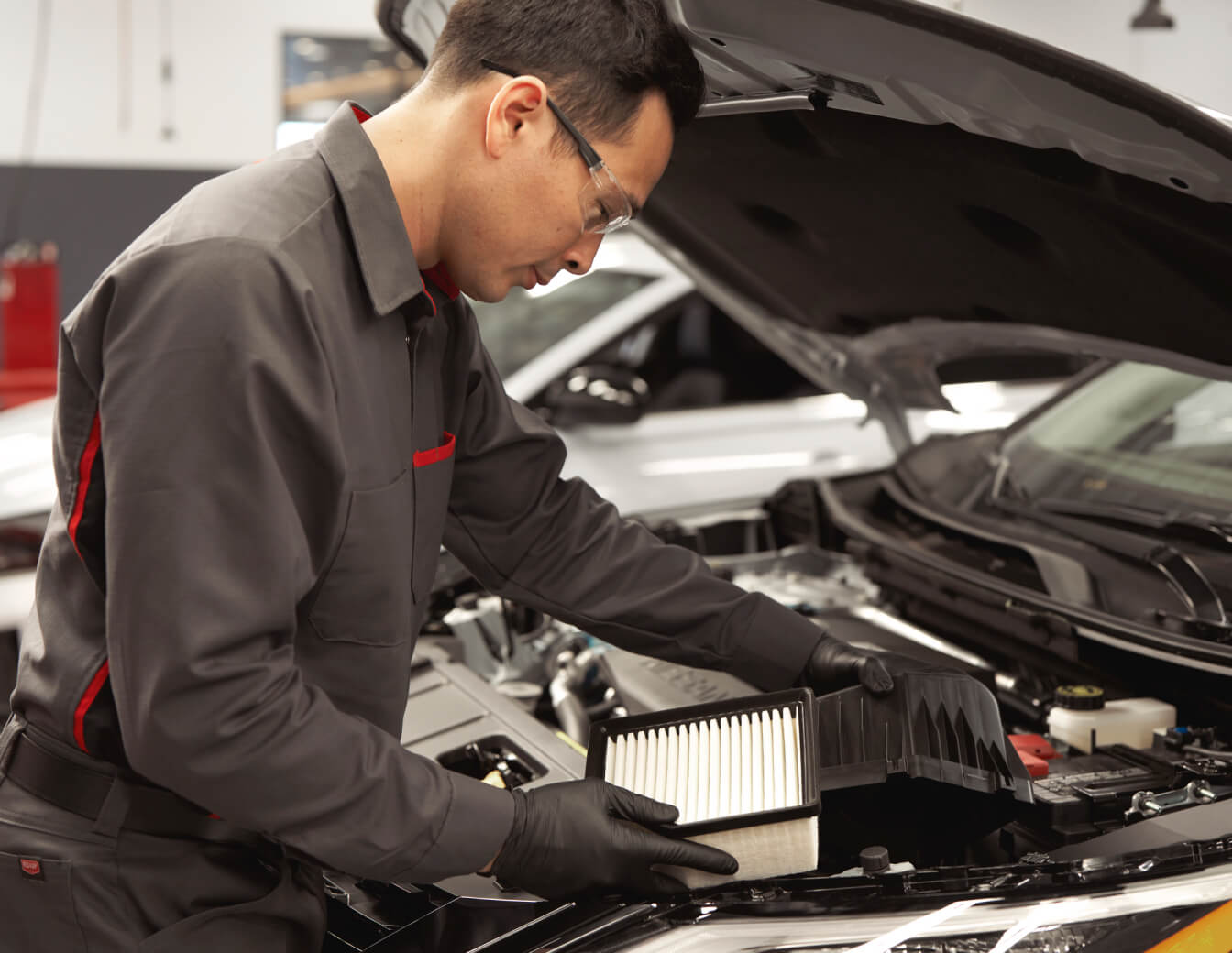 Certified Nissan automotive technician diligently working on a Nissan vehicle.