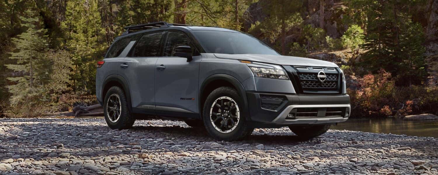 A gray 2025 Nissan Pathfinder Rock Creek driving done a road made of stones