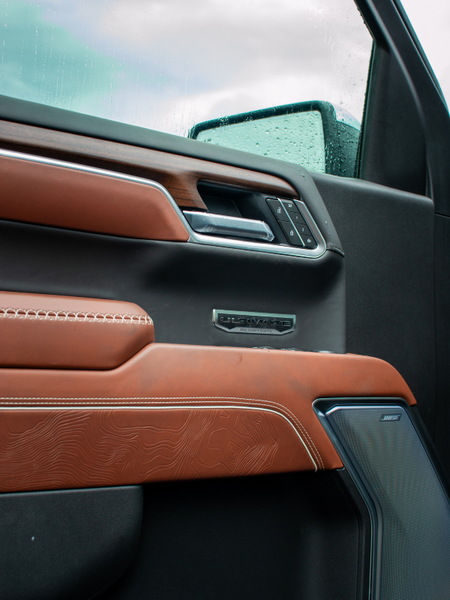 Brown Sierra Denali Ultimate interior door panel with wood trim and speaker grille
