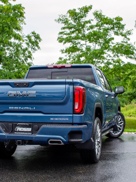 Rear three-quarter view of a blue GMC Sierra Denali Ultimate and its cargo bed