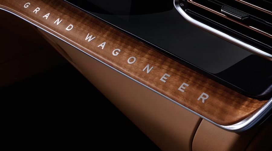 Close-up of the 2026 Jeep Grand Wagoneer handcrafted natural wood dashboard inlay with inlaid lettering, available at Route 18 Autos in East Brunswick, NJ.