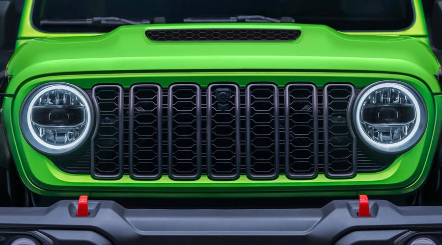 Close-up of a lime green 2026 Jeep Wrangler front grille and LED headlights, showcasing modern design and availability at Route 18 Autos in East Brunswick, NJ
