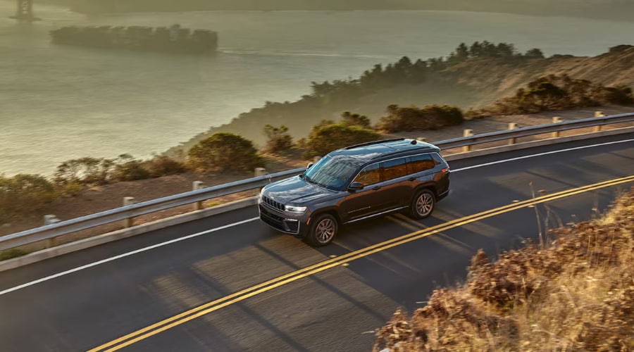 Side profile view of a 2026 Jeep Grand Cherokee parked near New Brunswick displaying its refined seven-slot grille and elegant design
