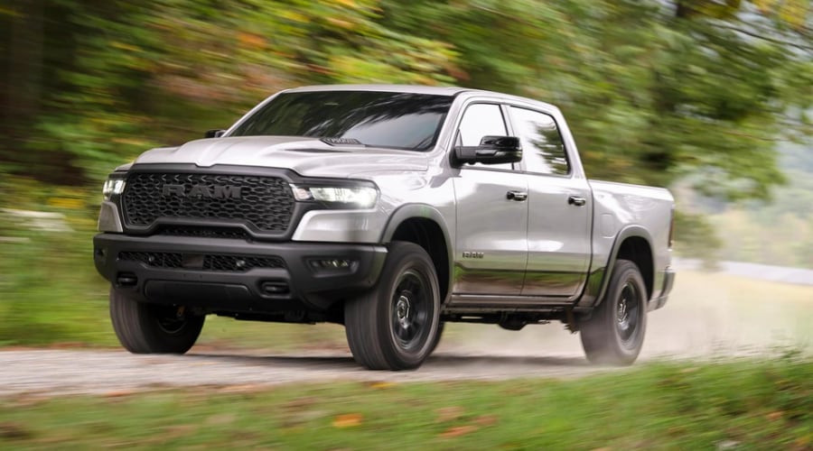 Silver 2026 Ram 1500 Crew Cab driving on a gravel trail with Active-Level air suspension raised for off-road ground clearance, available at Route 18 CJDR near East Brunswick and Old Bridge, NJ.