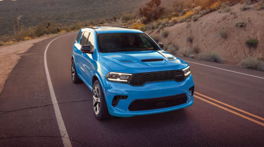 Front profile of a 2026 Dodge Durango SRT Hellcat driving through East Brunswick featuring the aggressive black grille and LED headlamps