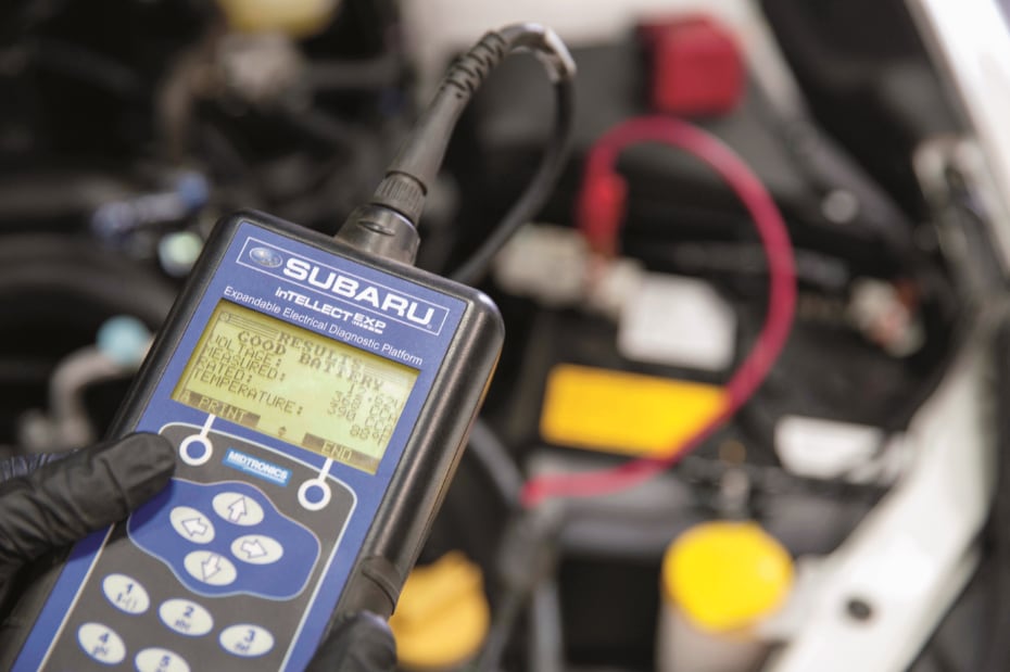 Subaru Service Technician Using a Diagnostic Tool on a Subaru Battery