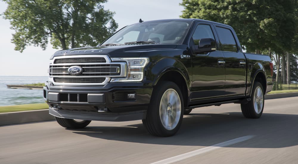 A black 2019 Ford F-150 Limited is shown driving on an open road.