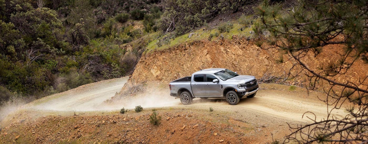 A silver 2024 Ford Ranger is shown from the side on a trail after leaving a dealer that has Ford trucks for sale.