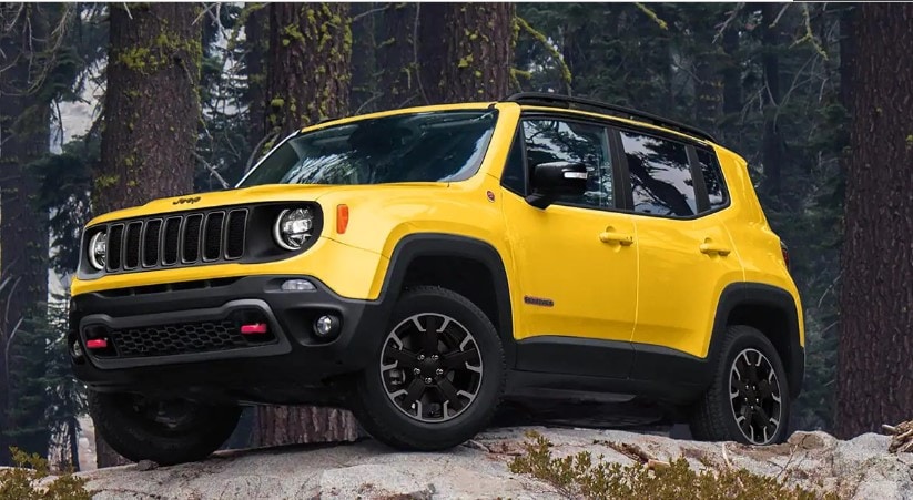  Yellow 2023 Jeep Renegade parked in a forest and mountain area
