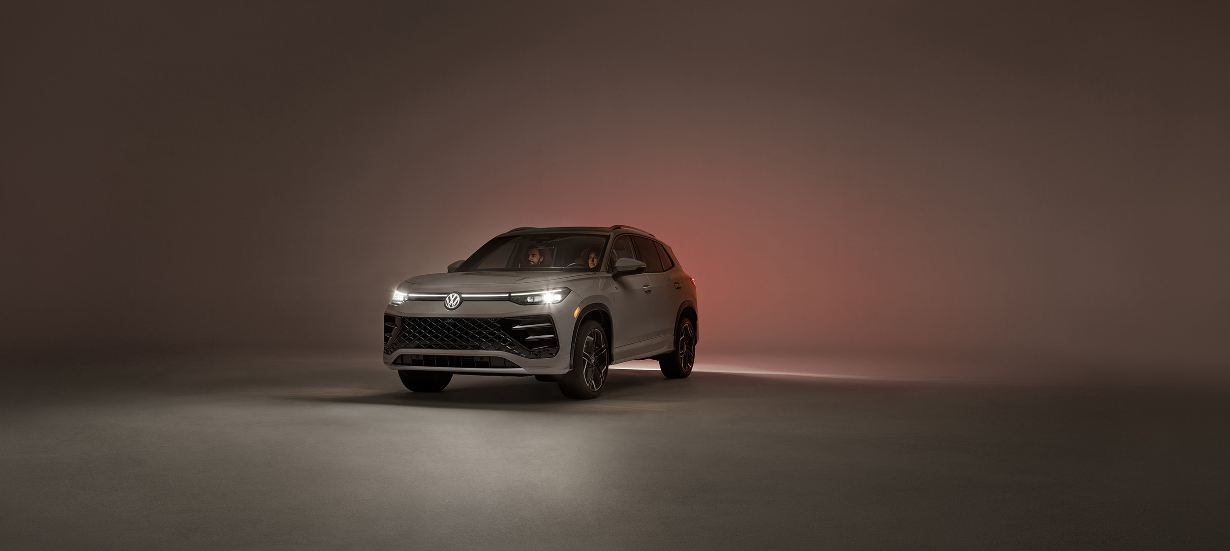 2025-Volkswagen-Tiguan with couple inside and headlights on