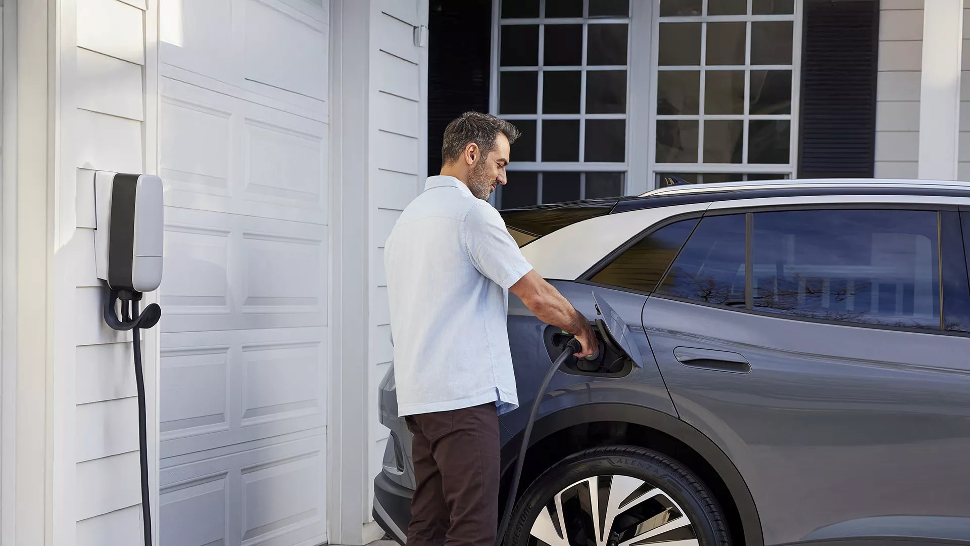 2025-volkswagen-id.4-side-view-man-charging-car.png