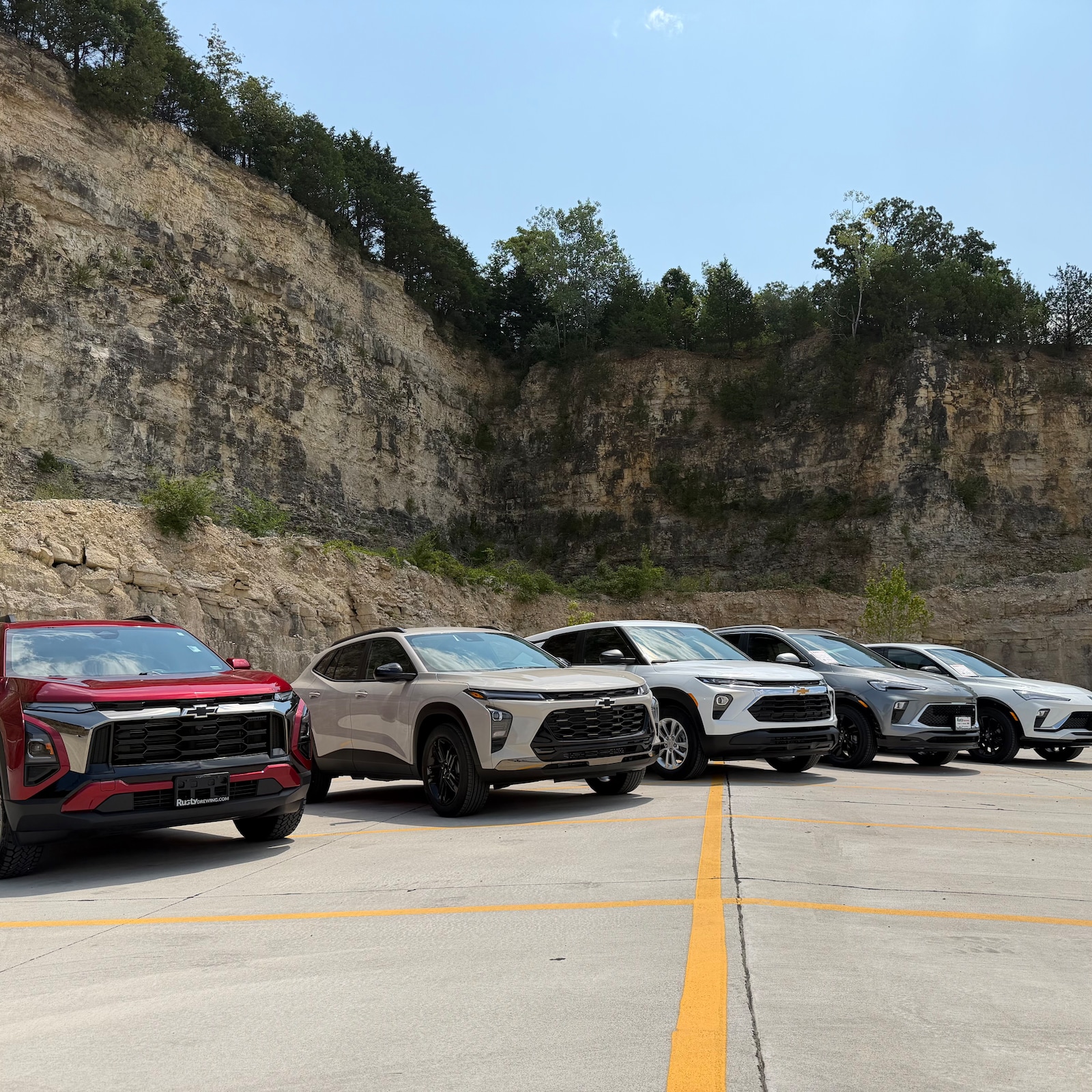 Three new Chevrolet SUVs and two new Buick SUVs lined up against the limestone bluff at Rusty Drewing in Jefferson City, Missouri