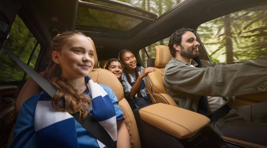 Interior view of the 2027 Jeep Grand Cherokee showcasing spacious Wicker Beige leather seating, panoramic sunroof, and a family enjoying a ride in New Jersey, available at Salerno Duane Chrysler Jeep Dodge Ram.
