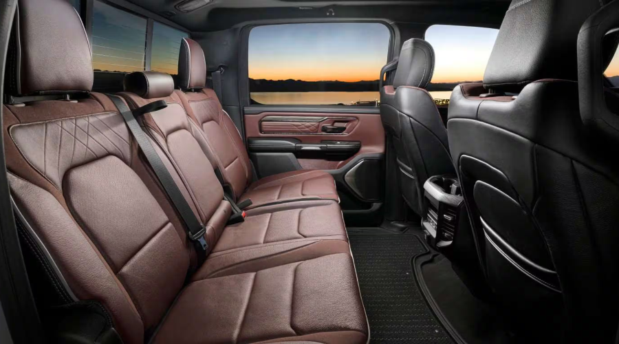 Spacious rear seats of the 2027 Ram 1500 featuring premium quilted dark saddle brown leather upholstery, generous legroom, and luxury door trim, available at Salerno Duane Chrysler Jeep Dodge Ram [ChIJ5aw-tFOvw4kR3YA0kWfzzvY] in Summit, NJ.