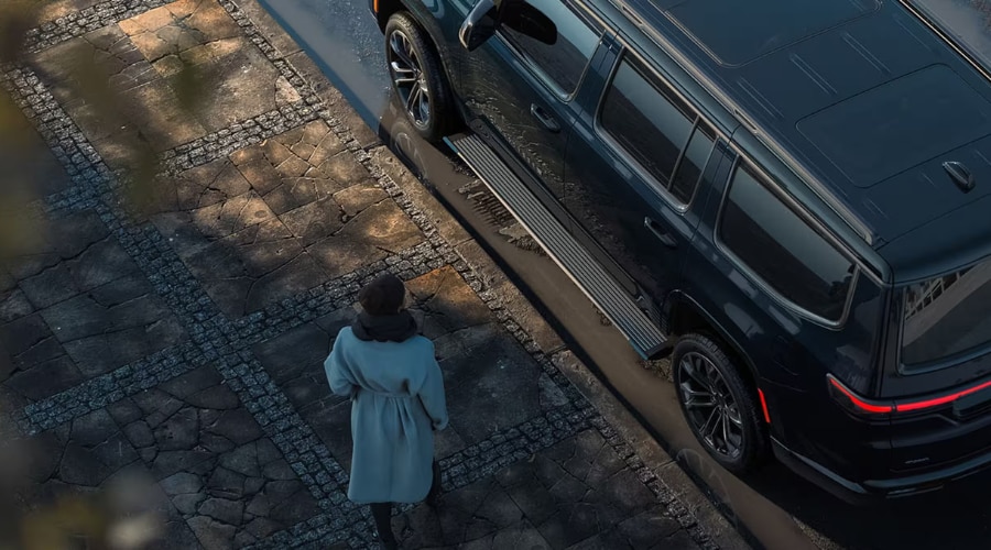High-angle view of a Classic Black 2026 Jeep Grand Wagoneer parked on a paved driveway, highlighting its premium design lines for luxury three-row SUV buyers in Edison, NJ.