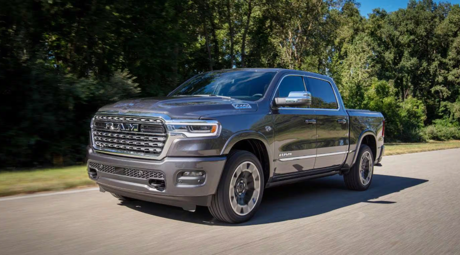 Dark Granite Crystal Metallic 2027 Ram 1500 driving along a tree-lined highway, highlighting chrome grille details and Hurricane twin-turbo engine performance at Salerno Duane Chrysler Jeep Dodge Ram in Summit, NJ.
