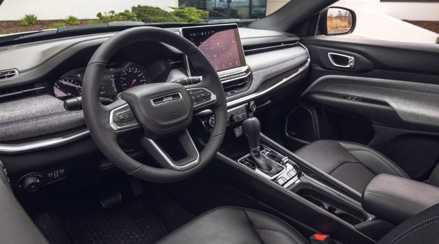 2026 Jeep Compass, front driver side photo detailing the infotainment System and 8.4 inch touch screen display