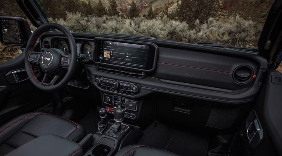 2026 Jeep Wrangler cabin interior featuring red-stitched leather seats, leather steering wheel, and 12.3-inch Uconnect 5 touchscreen displaying Off-Road Pages trail navigation for drivers in Summit, Morristown, and Chatham, NJ.