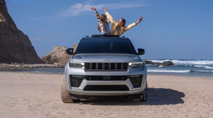Father driving a 2026 Jeep Grand Cherokee with a smiling daughter in the rear leather seating during a peaceful suburban commute near Summit and Morristown, NJ, available at Salerno Duane CJDR in Union County.