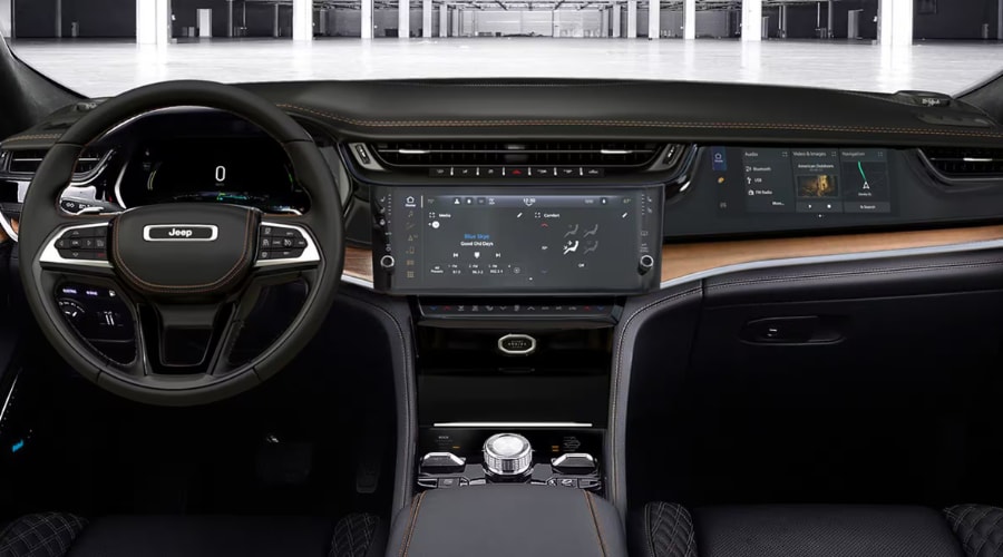 Full cockpit view of a 2026 Jeep Grand Cherokee dashboard featuring the digital driver cluster, 12.3-inch central Uconnect 5 touchscreen, and class-exclusive 10.25-inch front passenger interactive screen at Salerno Duane CJDR near Summit, NJ in Union County.