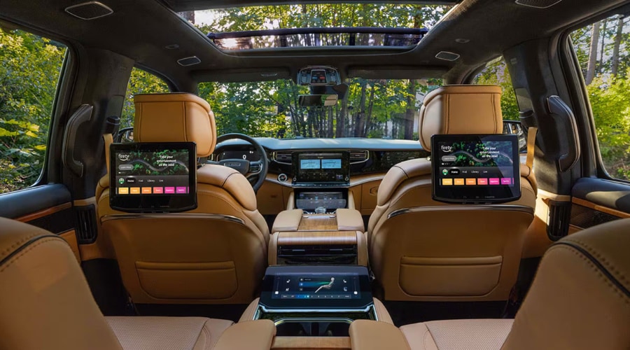 Interior passenger view of the tan leather cabin of a 2026 Jeep Grand Wagoneer, showcasing premium rear-seat entertainment screens for family road trips in the Old Bridge, NJ area.