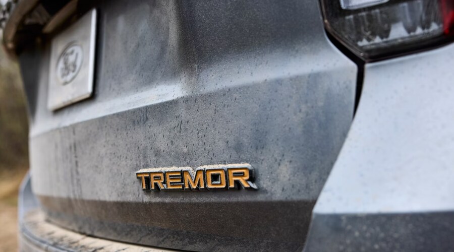 Rear view of an earthy tan 2026 Ford Explorer Tremor climbing a rocky off-road terrain Salerno Duane Ford in Summit, NJ
