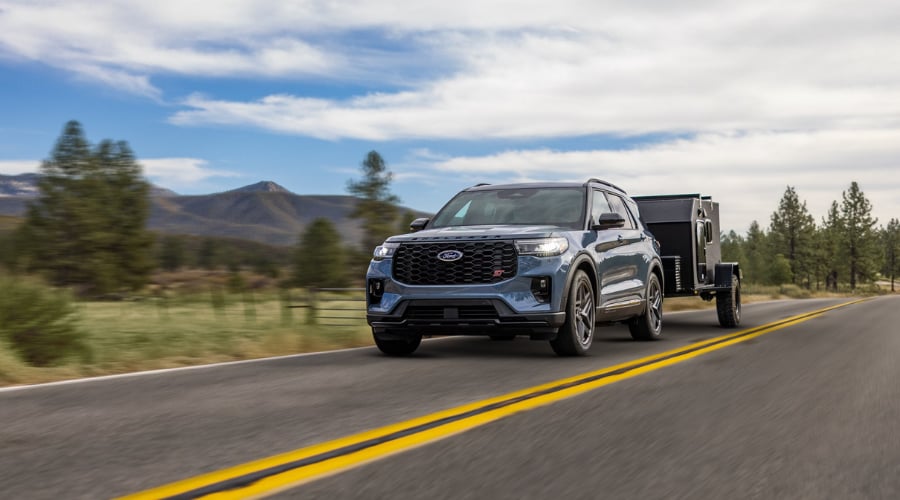 Front profile of a 2026 Ford Explorer driving through Summit showing its bold grille design and athletic stance