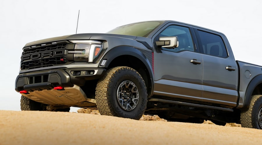 Front profile of a 2026 Ford F-150 in Summit showing the updated grille and LED headlamps against a suburban backdrop.