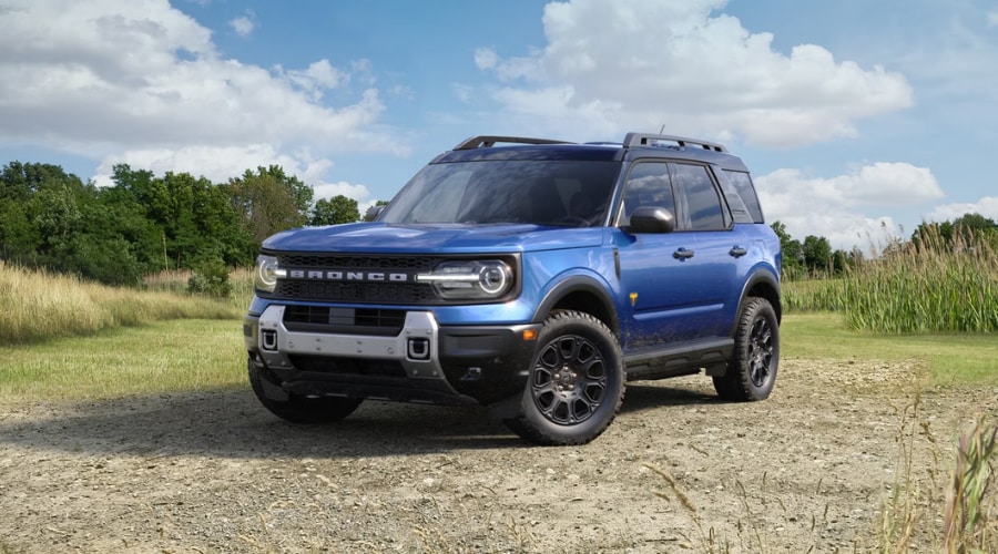 Front profile of a 2026 Ford Bronco Sport in Summit driving past Union Place and showing its rugged compact design