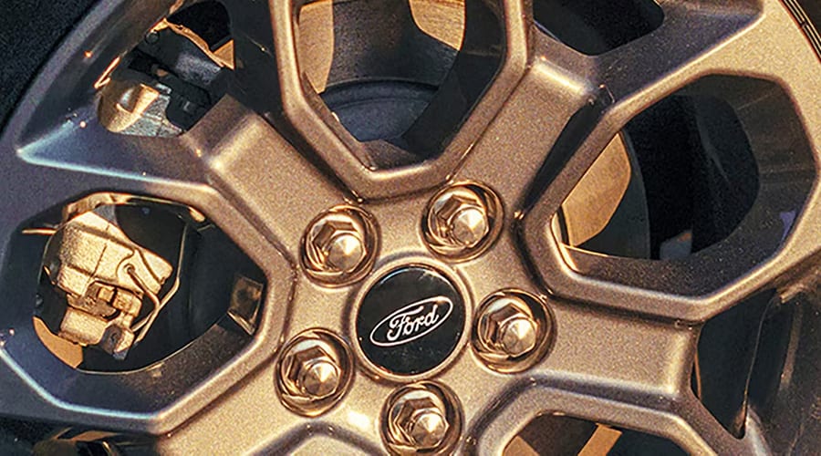 Close-up view of a Ford Maverick dark alloy wheel rim and brake rotor, showcasing rugged wheel engineering for North Jersey drivers across Union and Morris Counties.
