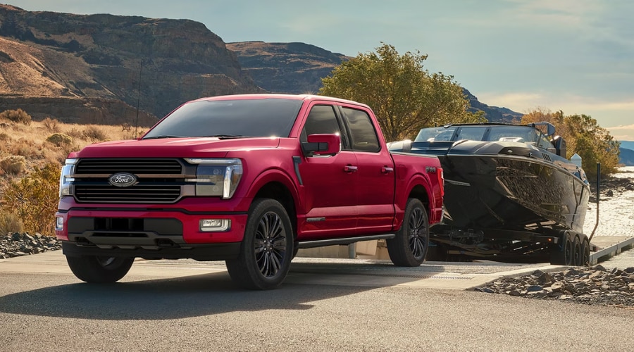 A 2026 Ford F-150 towing a boat at a lakeside ramp, demonstrating high-torque towing performance for recreational weekend getaways near Summit, NJ
