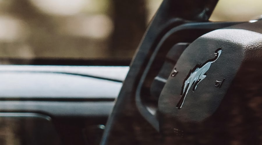 Close-up of the leather-wrapped steering wheel featuring the embossed bucking horse logo and driver-assist controls in a 2026 Ford Bronco SUV at Salerno Duane Ford in Summit, NJ