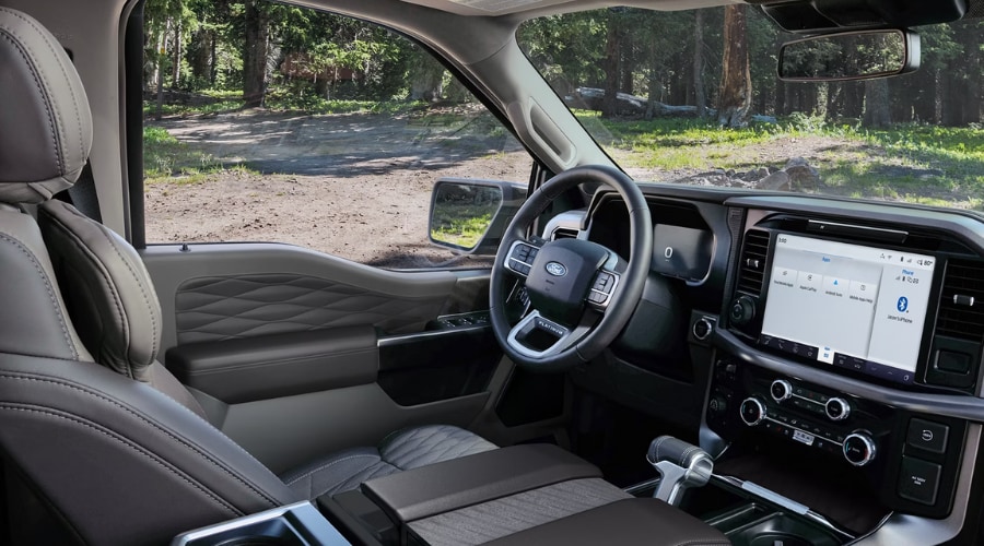 Interior driver cabin of a 2026 Ford F-150 showing the digital dashboard and premium quilted leather trims parked at a campsite, ready for Morristown area weekend getaways