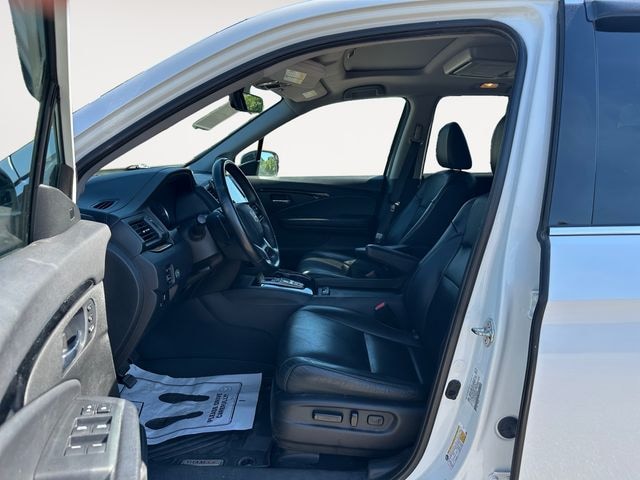 Interior of a used Honda Pilot Elite showing the front cabin and second-row captain's chairs at Sanford Imports near Raleigh, NC