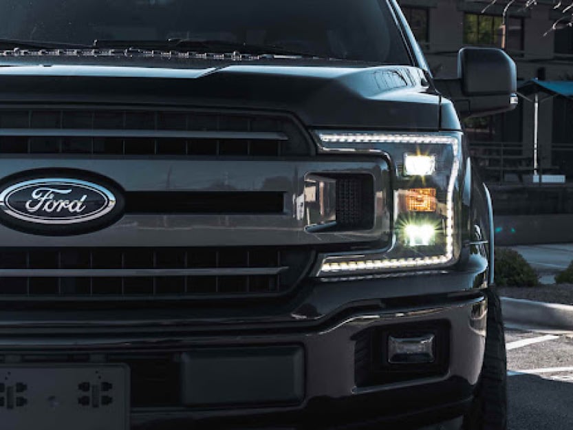A close up of car headlights appearing dim at night.