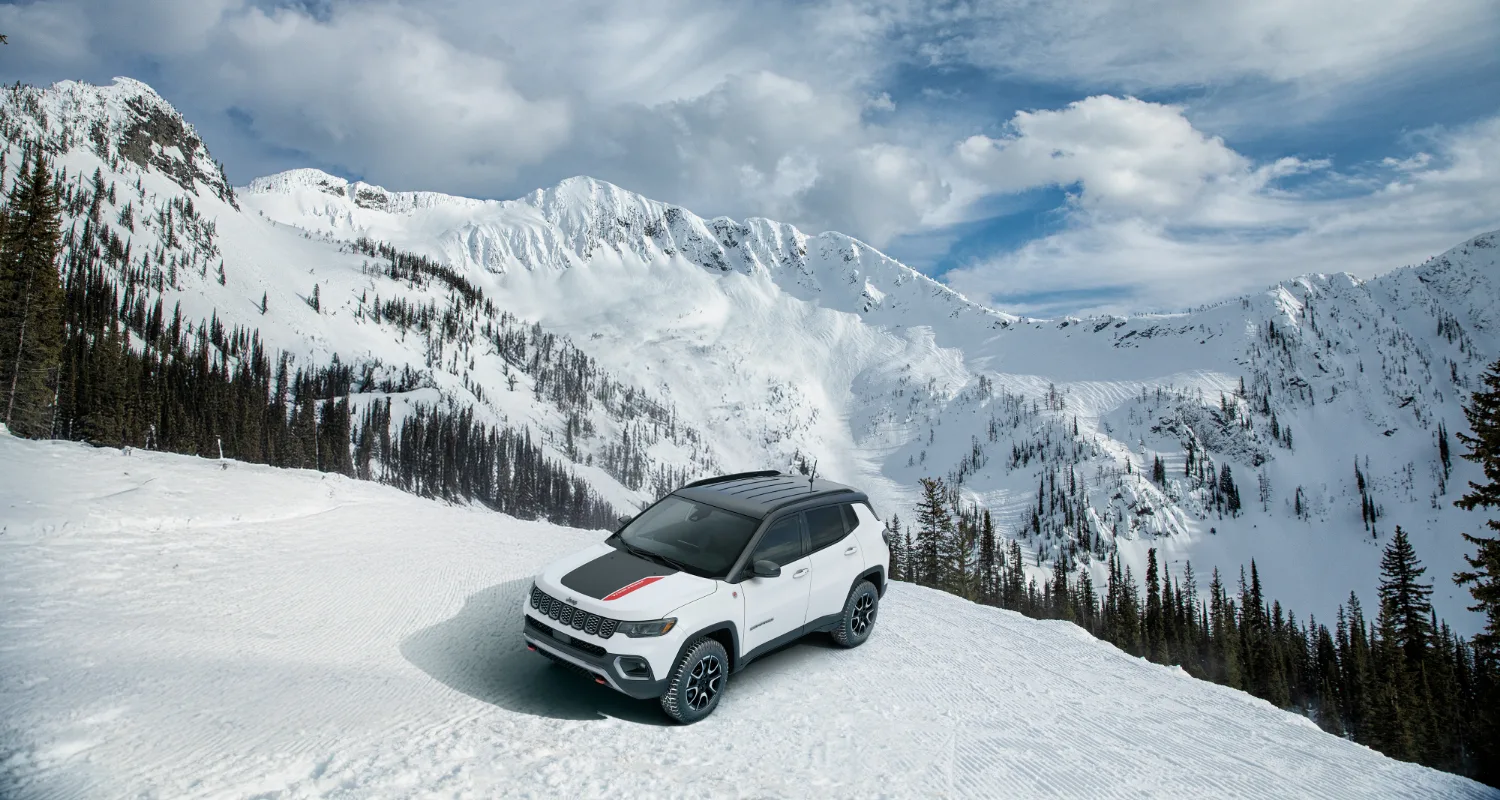 White Jeep Compass in a snowy mountain view