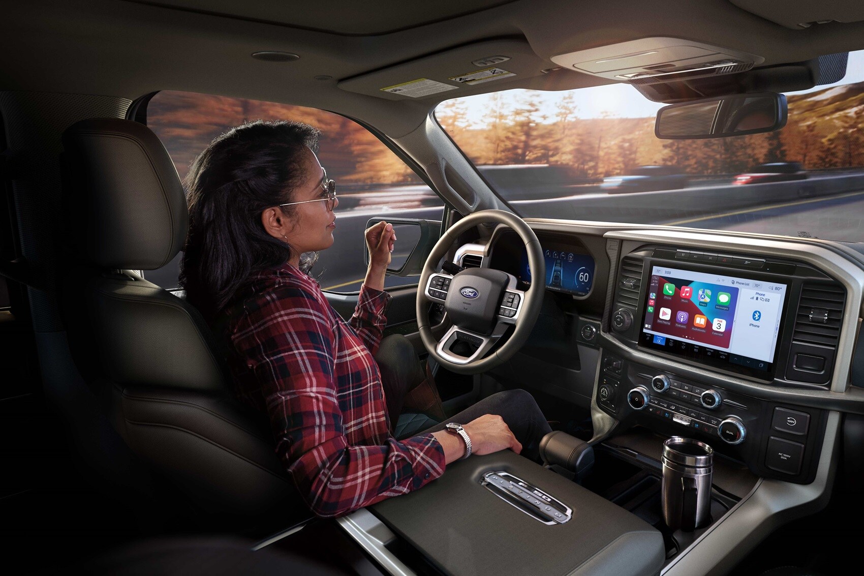Interior view of woman driving a Ford vehicle on a scenic road