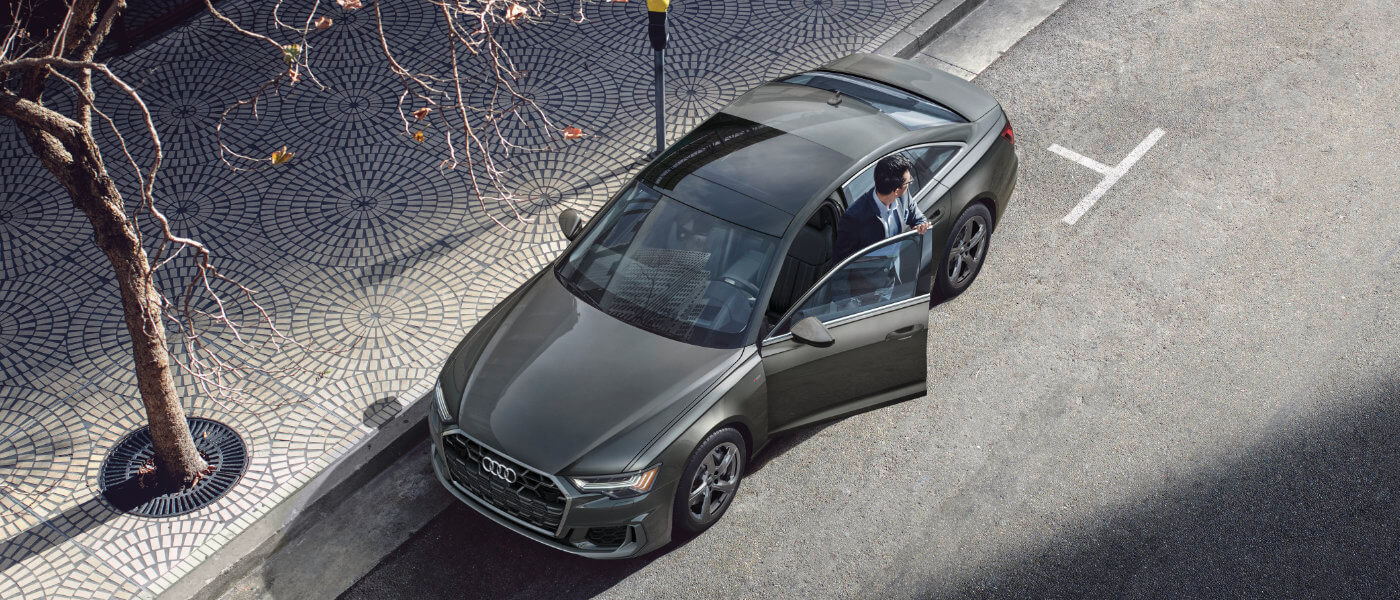 2024 Audi A6 sedan exterior parked on street with driver exiting car
