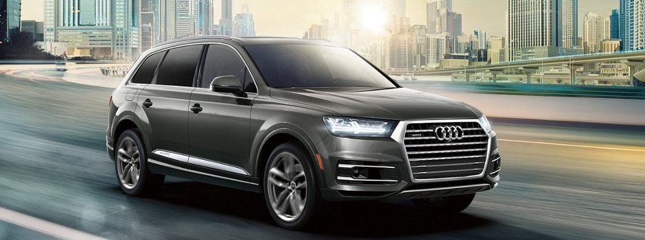 2018 Audi Q7 driving past the city skyline