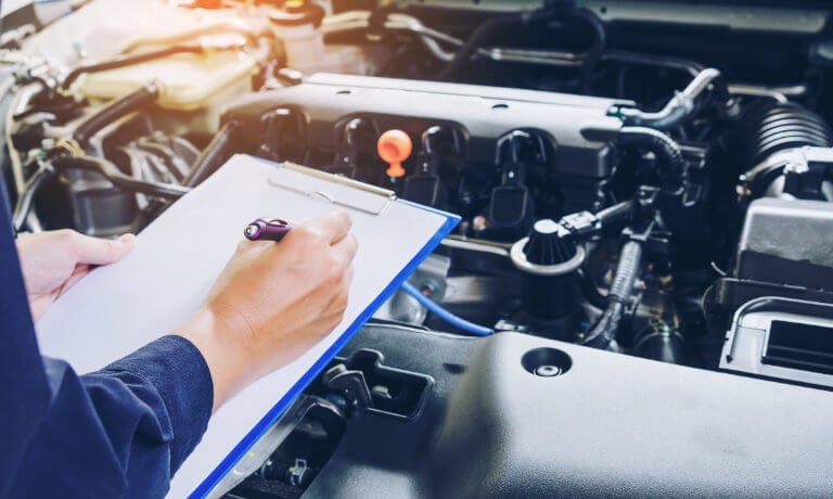 Service technician clipboard inspecting vehicle