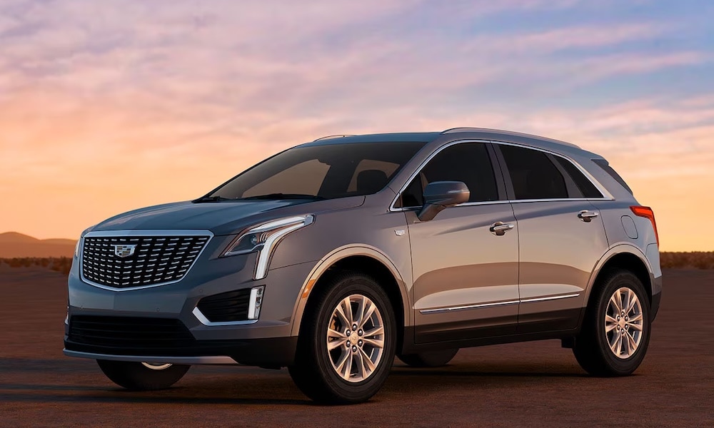 A gray 2026 Cadillac SUV parked in the desert at sunset A gray 2026 Cadillac SUV parked in the desert at sunset