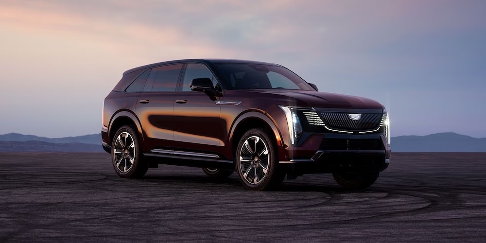 A dark red 2026 Cadillac Escalade IQ SUV at twilight A dark red 2026 Cadillac Escalade IQ SUV at twilight