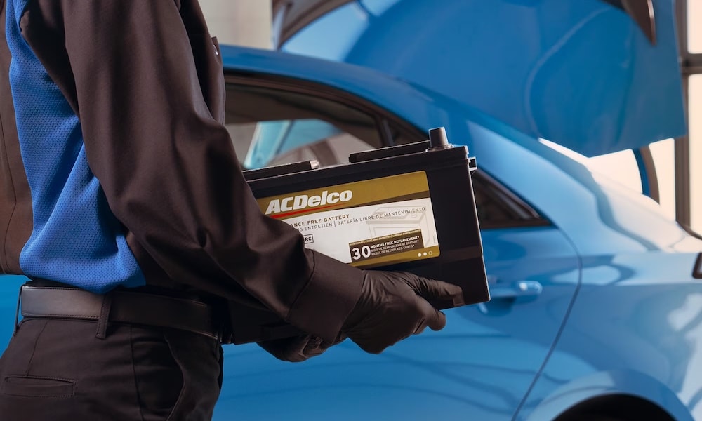 A service technician carrying an AC Delco battery