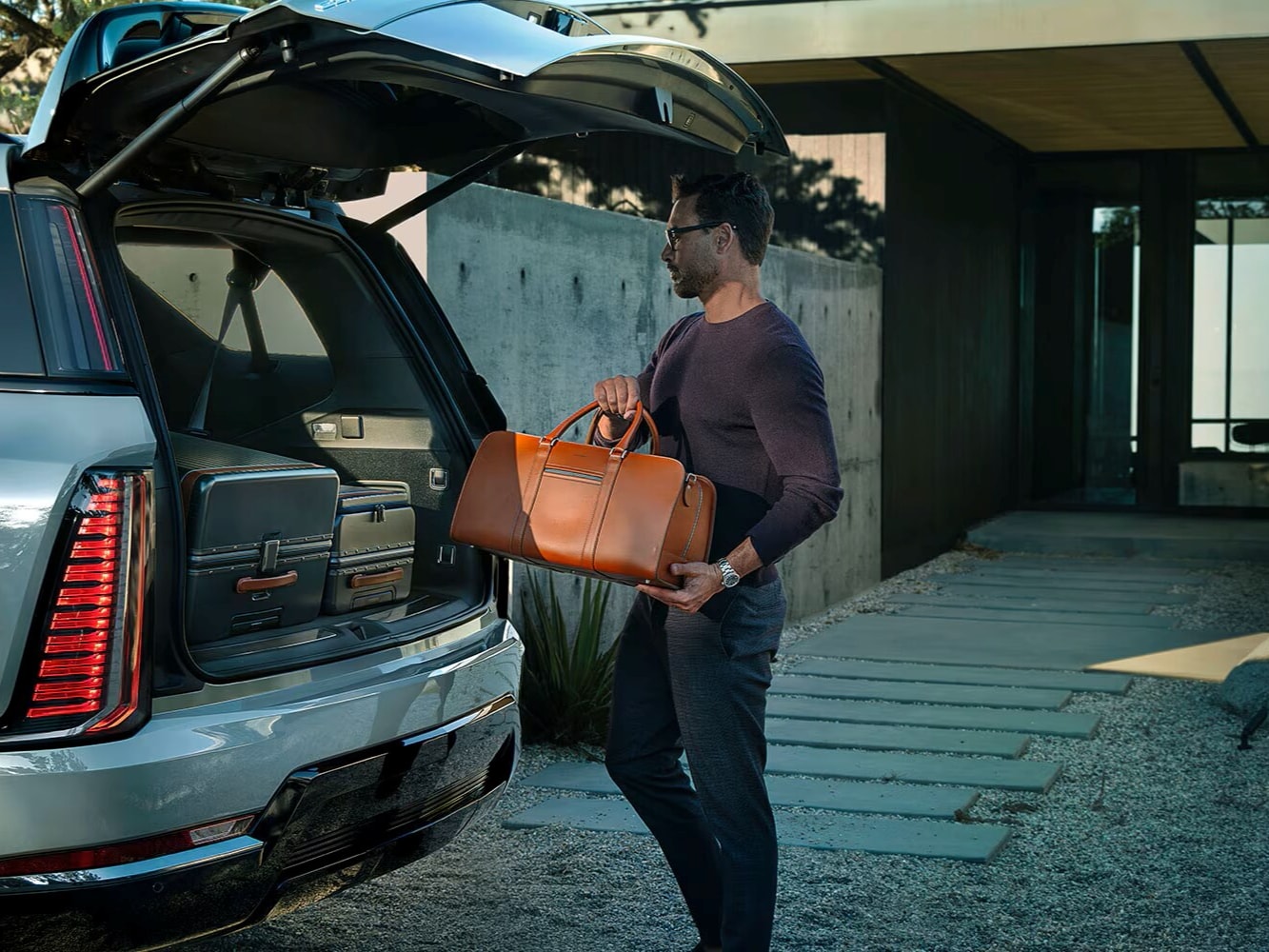 Close-up of a Man Loading Cargo Into the Spacious Trunk of a 2026 ESCALADE IQL