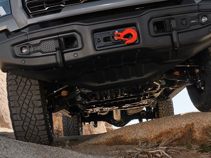 Close-up of the Front End on a 2026 GMC Sierra HD AT4X Heavy Duty Off-Road Truck Driving on Rocky Terrain