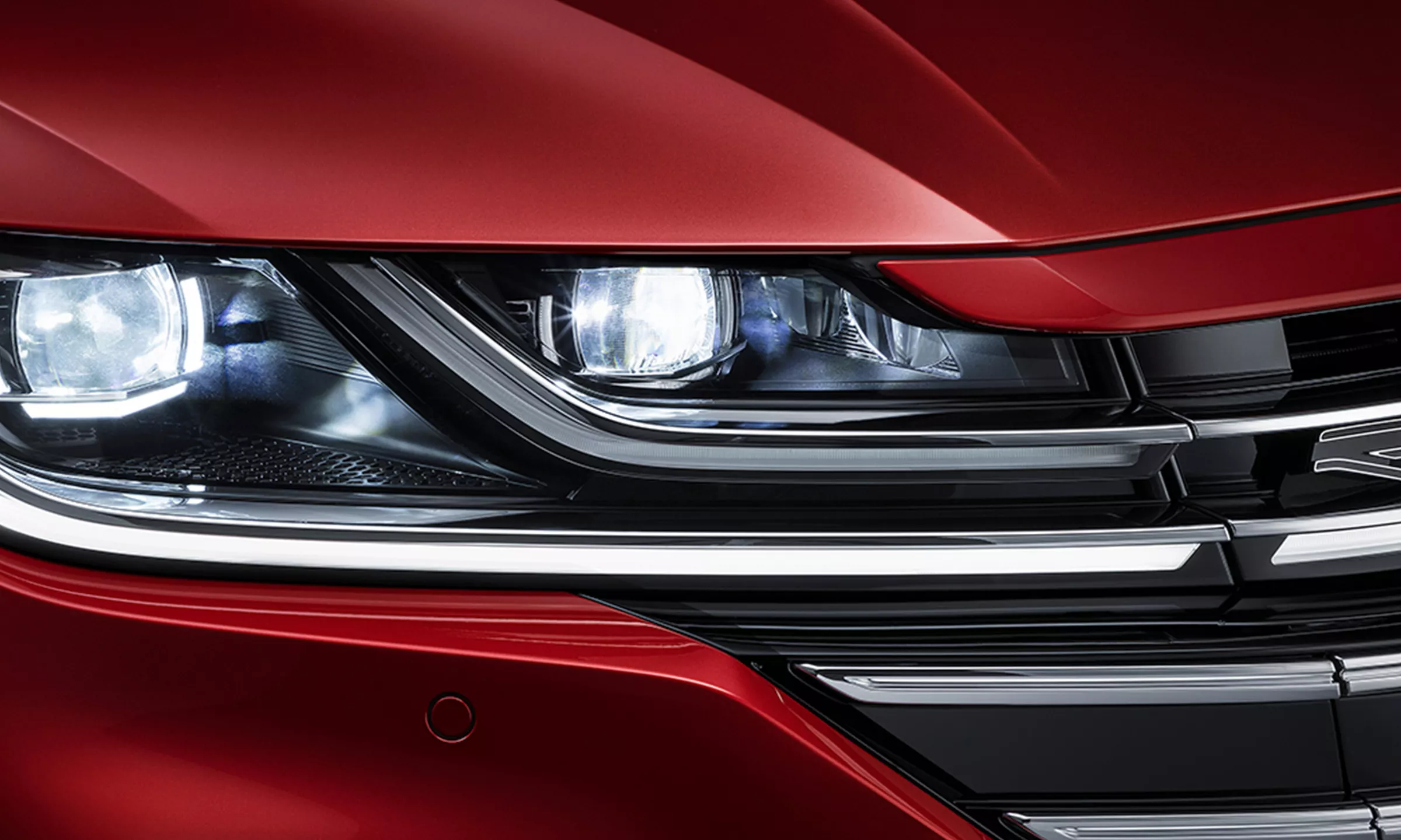 Arteon in Kings Red Metallic; front view of LED headlights with Daytime Running Lights